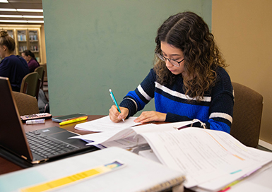 Student studying surrounded by papers