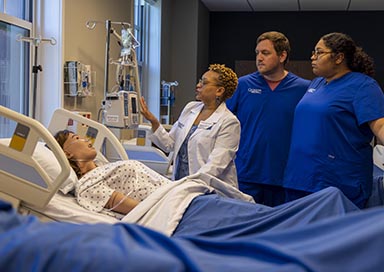 Professor teaching students in nursing lab