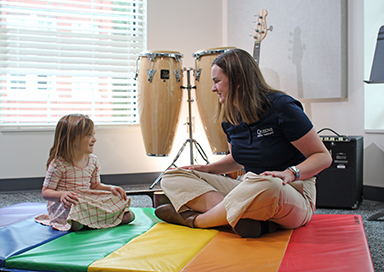 Student playing music with child