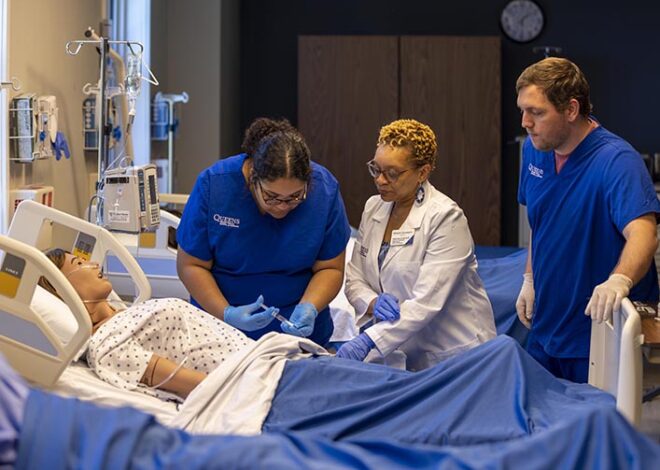 Nursing students and professor working with medical dummy
