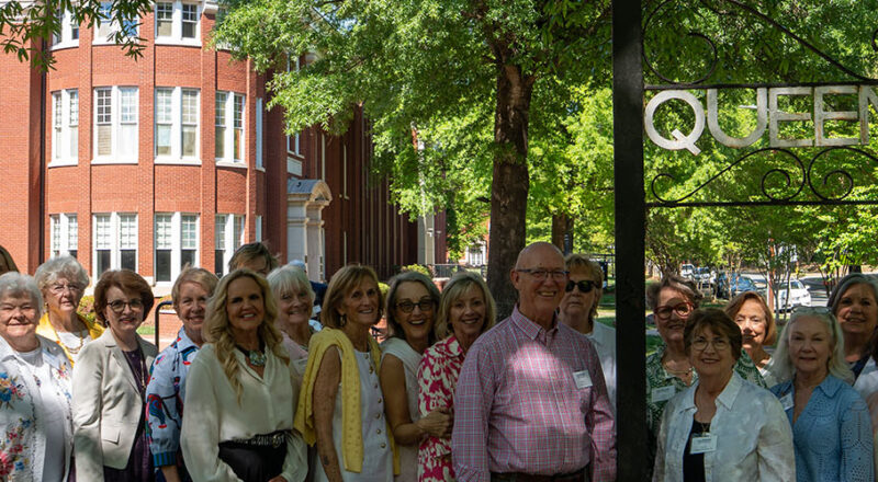 Alumni reunion weekend group at Queens sign