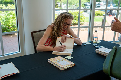 Author signing book at event