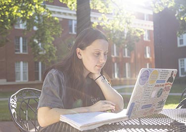 Student working on laptop outdoors