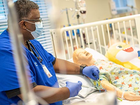 Nursing student injecting liquid into IV