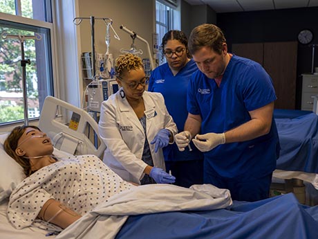 Student and professor working in Nursing Sim lab