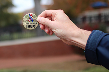 Student holding Support our Troops button