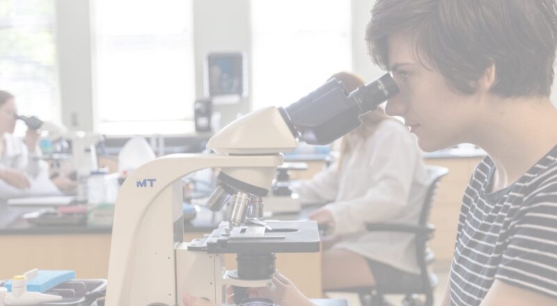 Female student looking into microscope