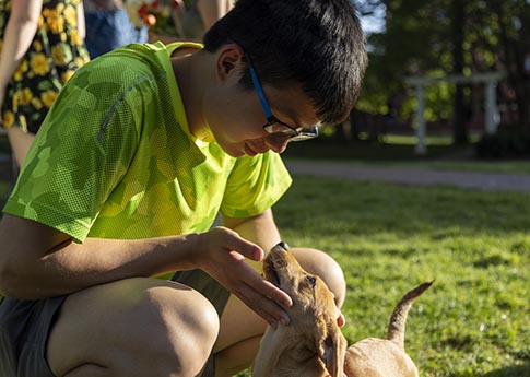 Student petting a small dog
