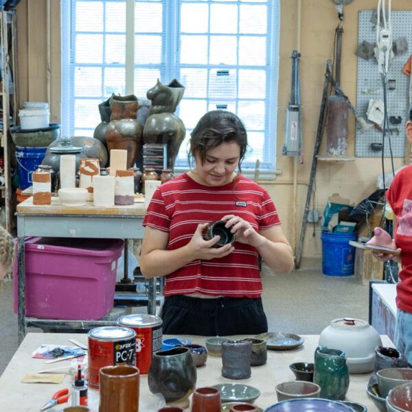 Student working with pottery