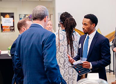 Student speaking with employers at Schmoozapalooza