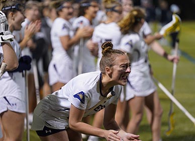 Queens Lacrosse player cheering on team