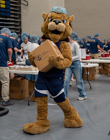 Rex carrying a box during food packing event