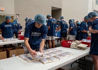 Faculty, staff, and student packing meals