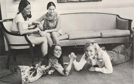 Girls arm wrestling in parlor