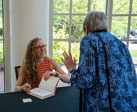 Virginia Evans signing book and speaking with attendee